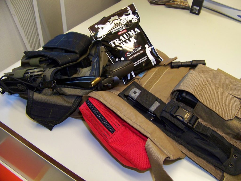 Two different kits for two different needs. On the right is a U.S. Palm plate carrier with Level III ballistic protection an entry tool from Tops and Blackhawk mag pouches for the AR-15. On the left, a basic emergency kit for any sort of violent encounter: Pistol, ammo, trauma kit, light, multi-tool.