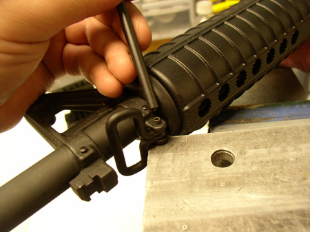Using a hard surface as an anvil for the rivet head, one can then use a roll pin punch to expand the rivet tip to secure the sling swivel to the front sight gas block.