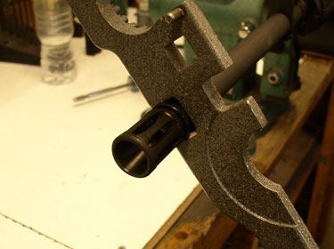 Adding the flash suppressor is simple. Place the crush washer with the wide end forward on the barrel threads and screw the device on. Use the large notch on the AR action wrench (DPMS model shown) to tighten. You have about one revolution worth in that crush washer, so don’t screw up.