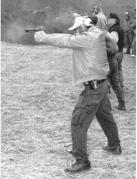 Power stance, high hand, crush grip, front sight, smooth roll. The author, foreground, brings it all together as he wins a shoot in the Northwest. Note that spent casing is in the air above his STI, but gun is already back on target despite recoil of full power .45 hardball. Photo by Matthew Sachs.