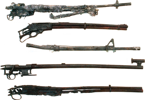 damaged-500 These inoperable sporting arms represent how your arms collection might appear after a house fire. Top to bottom: 1. What was a M14A1 with a bipod and the remains of a scope mount. The scope and much of the mount has melted, the barrel is warped upward, the entire stock assembly has been consumed along with many of the thin metal parts. 2. The Marlin Model 336 appears in better shape than some of the other arms, but the barrel/magazine tube assembly is warped, the stock and forearm are gone, and only the heavy forged steel receiver appears reasonably intact, although the action is inoperable. 3. The barrel of this AR-15 HBAR is slightly warped upward, as is the bolt carrier. However, the aluminum upper and lower receiver units, and synthetic stock and forearm did not fare well. 4. The Remington Model 37 target rifle was a massive design constructed almost entirely of steel and walnut. The stock was consumed, but most of the metal parts survived, even the receiver sight, which is not shown. The heavy barrel is warped slightly downward and to the right. 5. With their thin barrels, side/side and over/under shotguns do not come through house fires as well as pump and auto loading shotguns which tend to have heavier barrels. The barrels of this 20-gauge SKB over/under are literally falling apart, having been burnt through in several places.