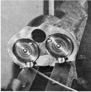 Darne-5 The Darne breech face, showing the obturator disks, the extractor hooks (at 6 o’clock) and the ejector pins. The large hole receives the round barrel lug, the latter secured by a vertical bolt. However, the main bolting is done by the toggle arm actuated by the operating lever, seen raised here.