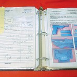 Open loose-leaf binder with sheet protectors on right show the illustrated record of the firearm or item, and the backside of the previous record (at left) shows receipts, bills of sale, and other documentation stored behind each firearm or item in its sheet protector.