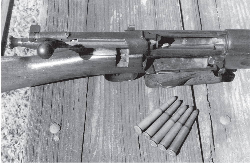 Krag-Jorgenson-Mag The unique Krag magazine, shown here with the right-side cover open, held five cartridges. The American Krag used the .30-40 Krag cartridge, and five original military cartridges are shown near the rifle. The Krag magazine could be loaded with the bolt either open or closed.