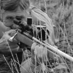 Prone in prairie grass, Wayne steadies a heavy-barreled .33 wildcat on a Remington action. The 4.5-14X Leupold is standard GreyBull fare. It has given him saucer-sized groups at 780 yards.