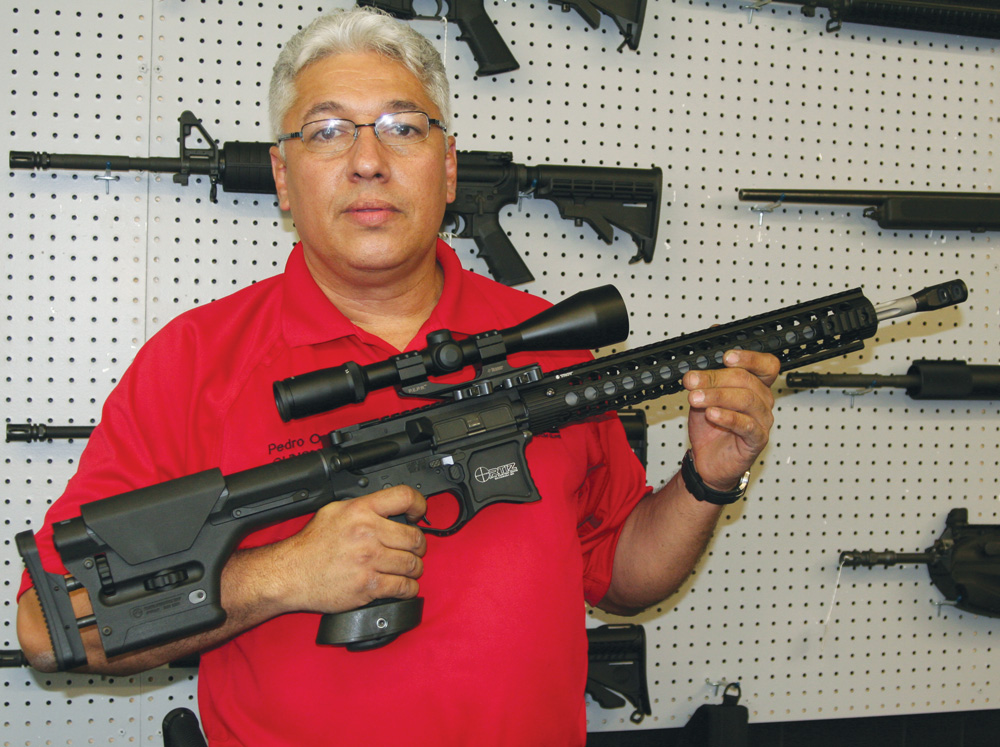 Pedro Ortiz, a self-taught gunsmith from Savannah, Ga. via Puerto Rico, holds the custom AR-15 that bears his name.
